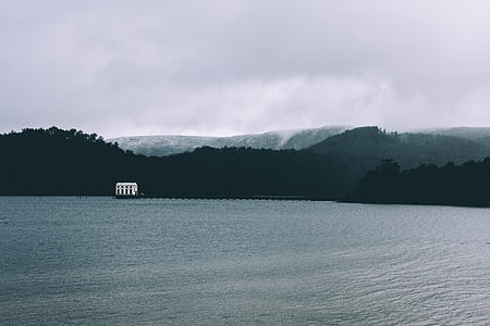 silhouette photo of mountain and body of water during daytime thumbnail
