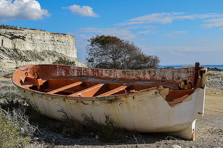 white boat on grey ground near body of water thumbnail