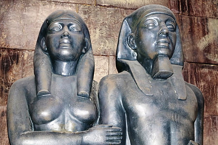two gray metal statuettes by wall thumbnail
