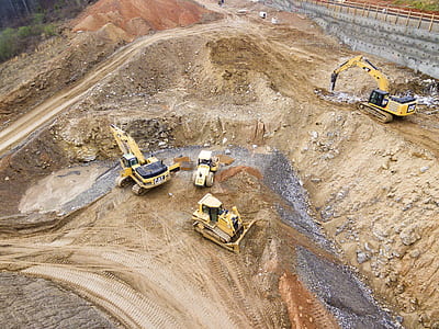 four yellow heavy equipment on sand thumbnail