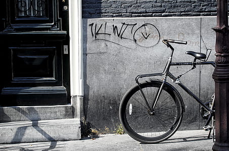 black city bike near closed black door thumbnail