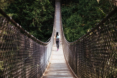 A young Asian woman walking on a suspension bridge thumbnail