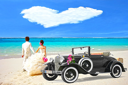 bride and groom beside black car on the beach photography thumbnail