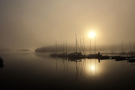 silhouette of boat near dock under cloudy sky thumbnail