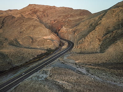 photo of empty road next to brown rocky hills thumbnail