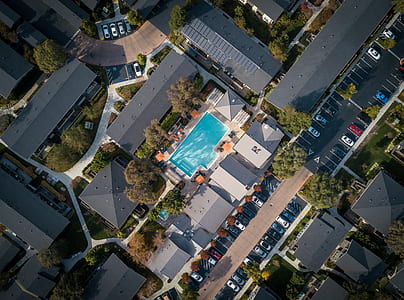 bird's eye view of swimming pool surrounded by gray roof houses thumbnail