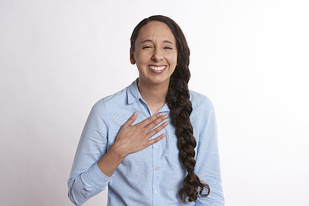 woman standing touching right chest thumbnail