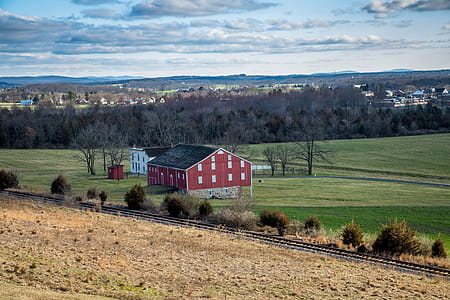 Red And Grey House In The Middle Of Green Grass Field thumbnail
