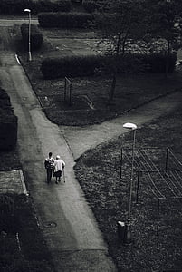 grayscale photo of two people walking on road thumbnail