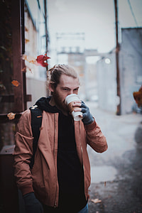 selective focus photography of man drinking cup thumbnail