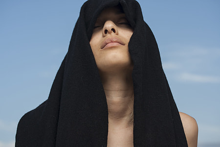 woman covering her forehead with black textile thumbnail