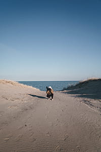 man wearing white cap and brown jacket using camera under clear blue sky thumbnail