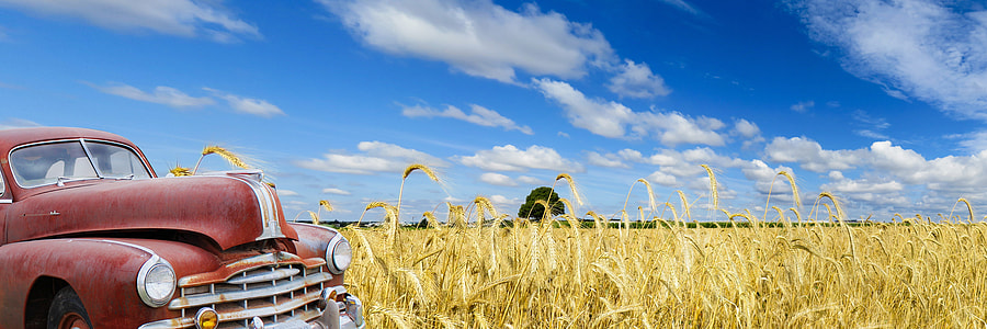 red car near wheat field photo thumbnail