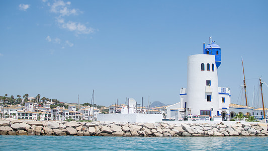 white lighthouse near body of water thumbnail