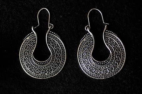 pair of silver-colored earrings on black surface thumbnail