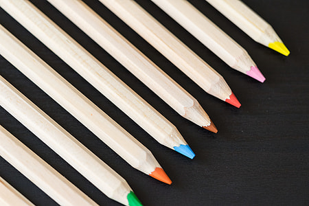Long Colored Pencils in a Row on Black Desk thumbnail