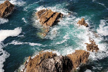 aerial photo of water waves on rock formations thumbnail