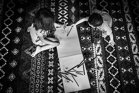 grayscale photography of two children holding color pens thumbnail