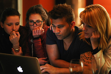 four people looking on turned-on silver MacBook thumbnail