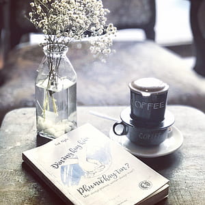 clear glass vase beside book thumbnail