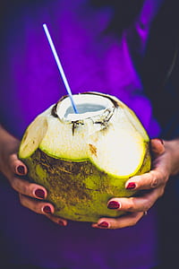 woman holding a coconut fruit with straw thumbnail