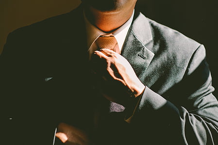 man wearing black suit with black background thumbnail