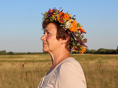 woman wearing white scoop neck shirt with floral headdress thumbnail