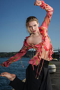 photo of woman in floral top in body bending near body of water thumbnail