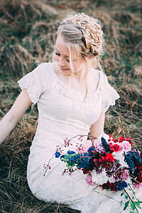 woman wearing white lace crew-neck cap-sleeved shirt sitting on ground holding variety of flower bouquet thumbnail