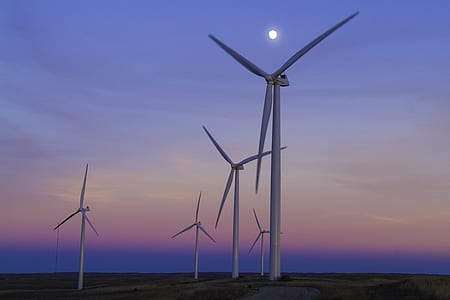 white metal wind turbines under blue cloudy sky photo thumbnail