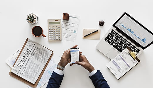 person holding smartphone in front of laptop thumbnail