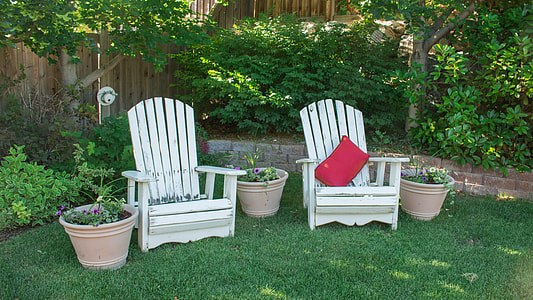 white wooden patio armchairs on green lawn grass during daytime thumbnail
