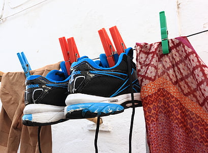 pair of black-blue-and-white Reebok low-top shoes hanged on black wire thumbnail