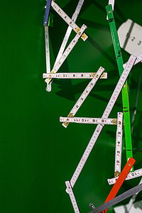 Extandable wooden ruler on a green background thumbnail
