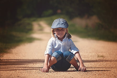 girl in white dress shirt sitting on pathway thumbnail