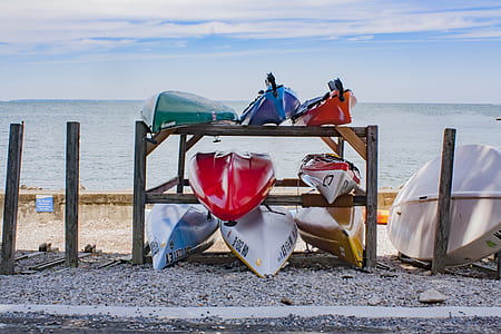 canoe boats on shoreline during daytime thumbnail