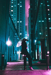 woman in black suit sitting on black and gray road bolster while holding clear umbrella at night thumbnail