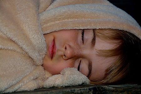 child sleeping with brown textile thumbnail