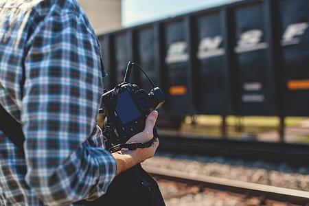 person holding black DSLR camera thumbnail