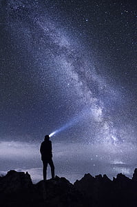 man standing on rock during night time thumbnail