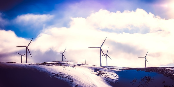 white wind turbines under white clouds thumbnail