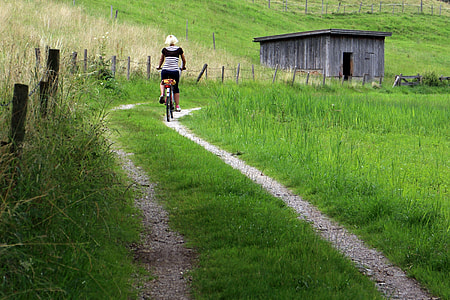 person riding bicycle near shed thumbnail