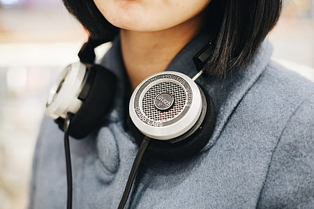 woman in gray suit while using gray and black headphones thumbnail