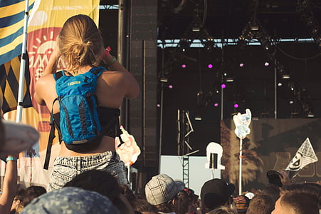 woman wearing blue backpack facing stage thumbnail