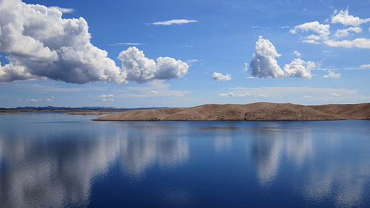 mountain near body of water under white clouds during daytime thumbnail