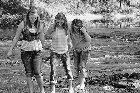 three women walking on river gray scale photo thumbnail