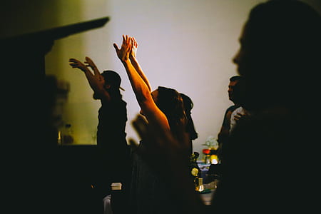 selective photography of woman raising her two hands surrounded with people thumbnail