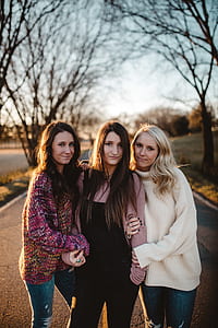 three woman standing in the middle of street thumbnail