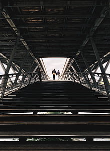 low angle photography of two persons walking on staircase thumbnail