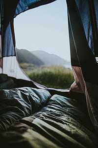 view of green grass and mountain inside tent thumbnail